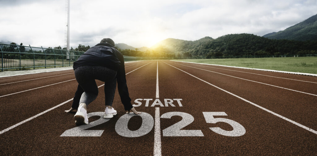 Word start 2025 written on athletics track and athlete woman runner in crouched posture at the start line at sunset for challenge and change.